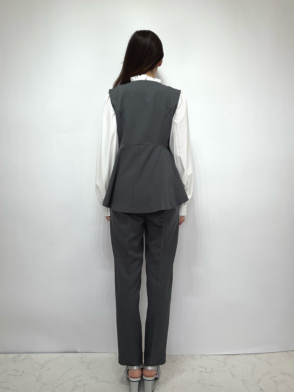 グレー系のスーツセットを着用したレディースの冬コーディネートの2枚目の写真