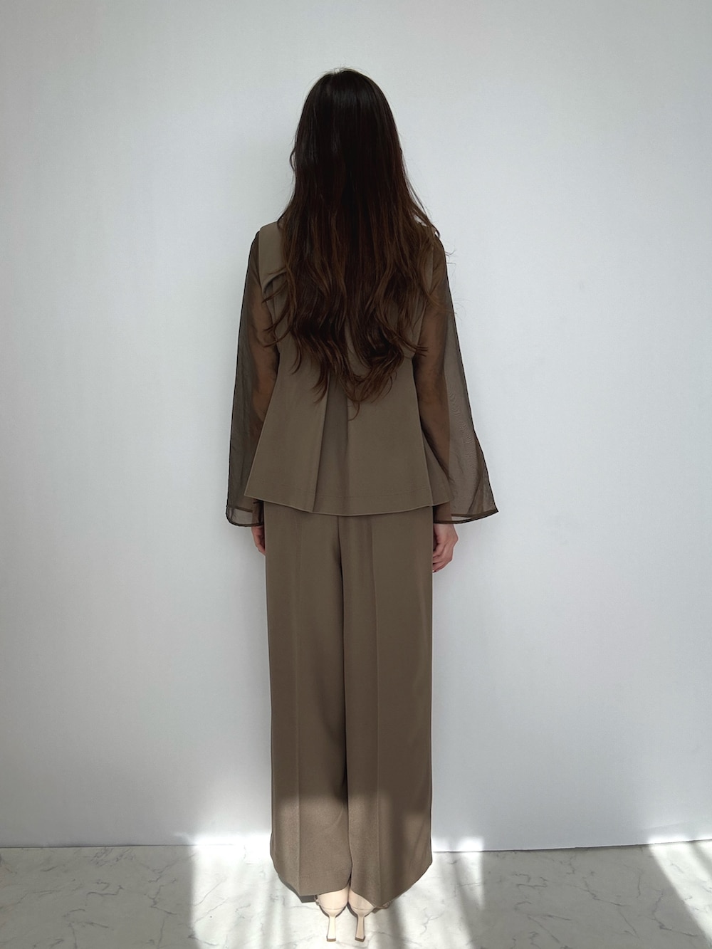 ブラウン系のスーツセット、ベージュ系のパンプスを着用したレディースの冬コーディネートの6枚目の写真