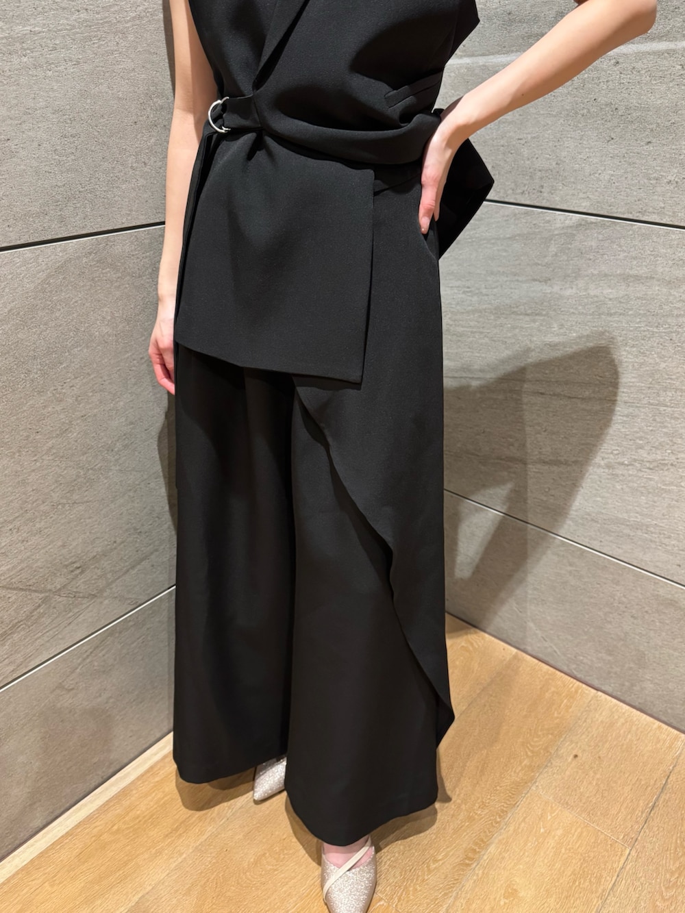 ブラック系のスーツセット、ベージュ系のパンプスを着用したレディースの冬コーディネートの2枚目の写真