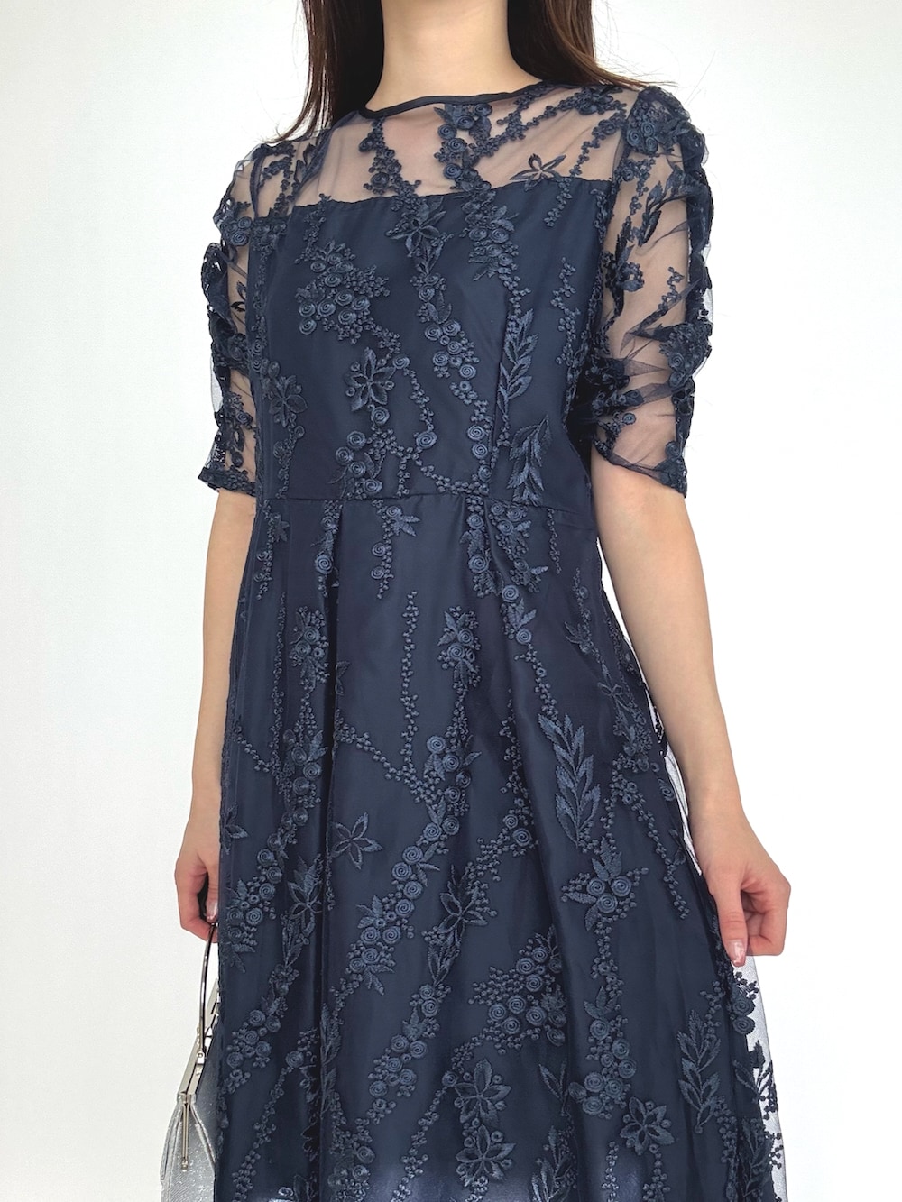 ブルー系のドレス、シルバー系のパンプス、シルバー系のクラッチバッグを着用したレディースの秋コーディネートの3枚目の写真