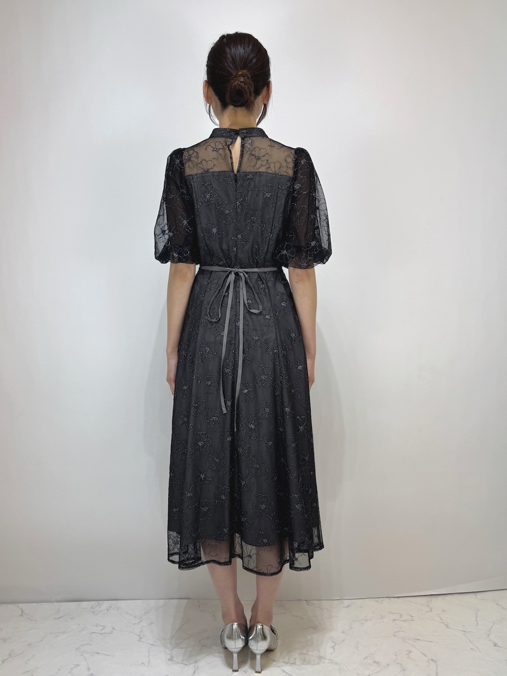 ブラック系のドレス、シルバー系のパンプスを着用したレディースの冬コーディネートの2枚目の写真