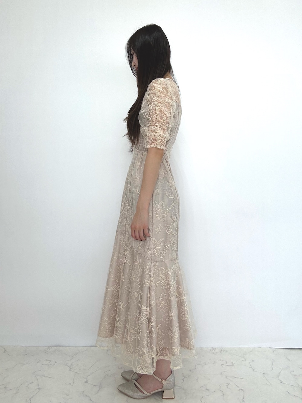 ベージュ系のドレス、ベージュ系のパンプスを着用したレディースの秋コーディネートの2枚目の写真