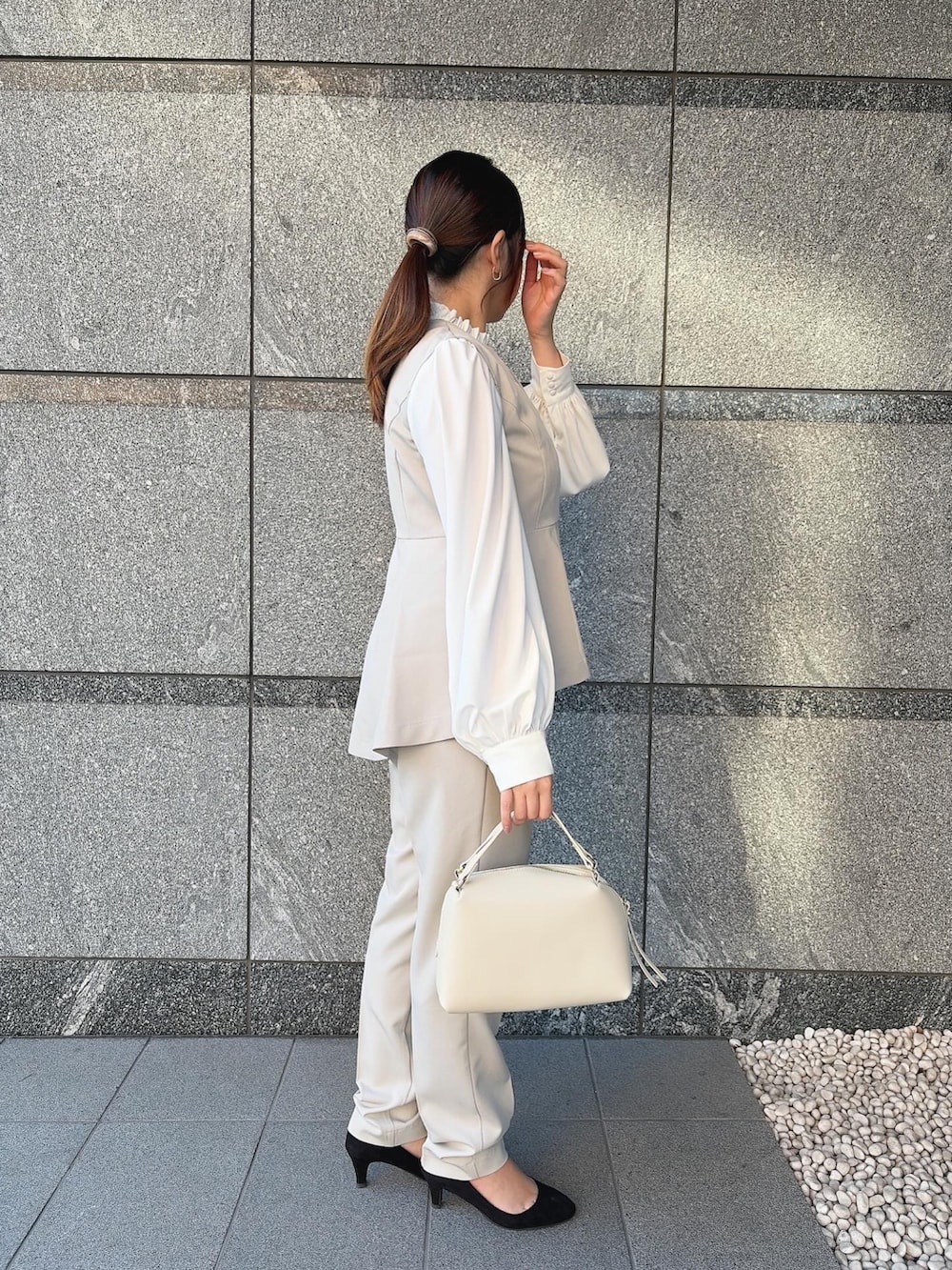 ベージュ系のスーツセットを着用したレディースの冬コーディネートの3枚目の写真