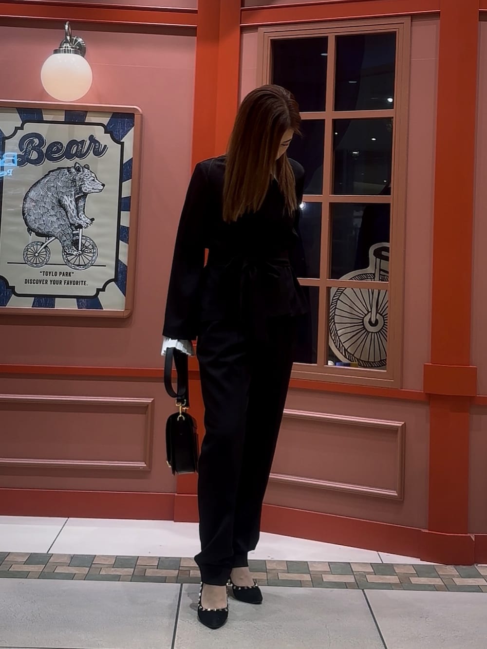 ブラック系のスーツセットを着用したレディースの冬コーディネートの3枚目の写真