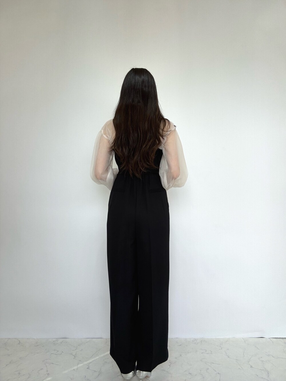 ブラック系のドレス、シルバー系のパンプス、ベージュ系のドレスを着用したレディースの秋コーディネートの5枚目の写真