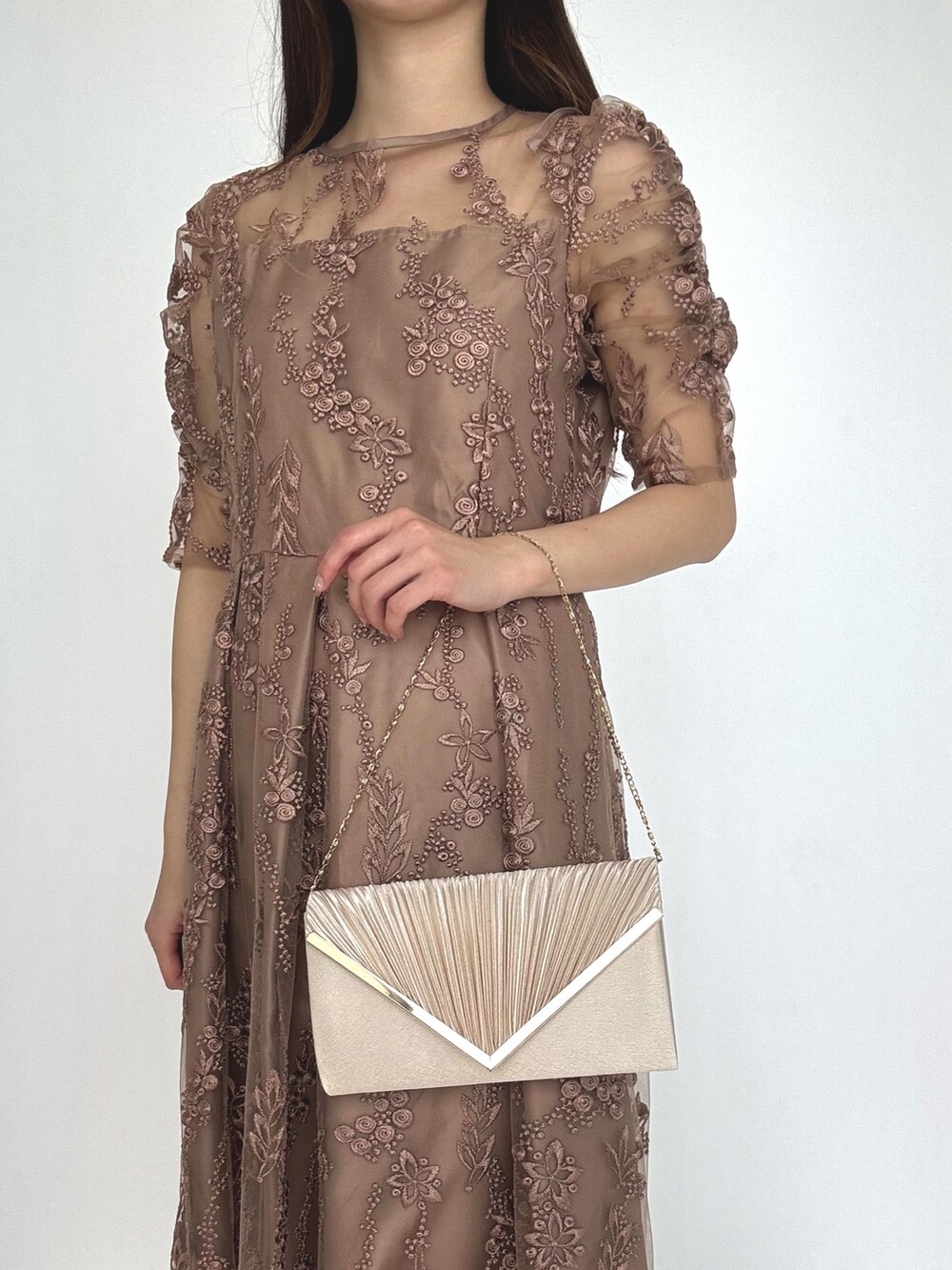 ベージュ系のクラッチバッグ、ブラウン系のドレスを着用したレディースの秋コーディネートの4枚目の写真