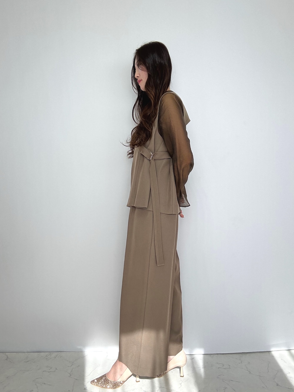 ブラウン系のスーツセット、ベージュ系のパンプスを着用したレディースの冬コーディネートの2枚目の写真