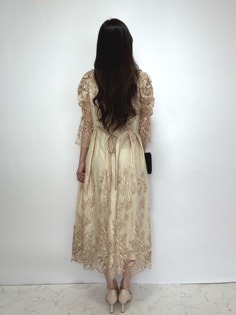 ベージュ系のドレス、ベージュ系のパンプスを着用したレディースの秋コーディネートの2枚目の写真