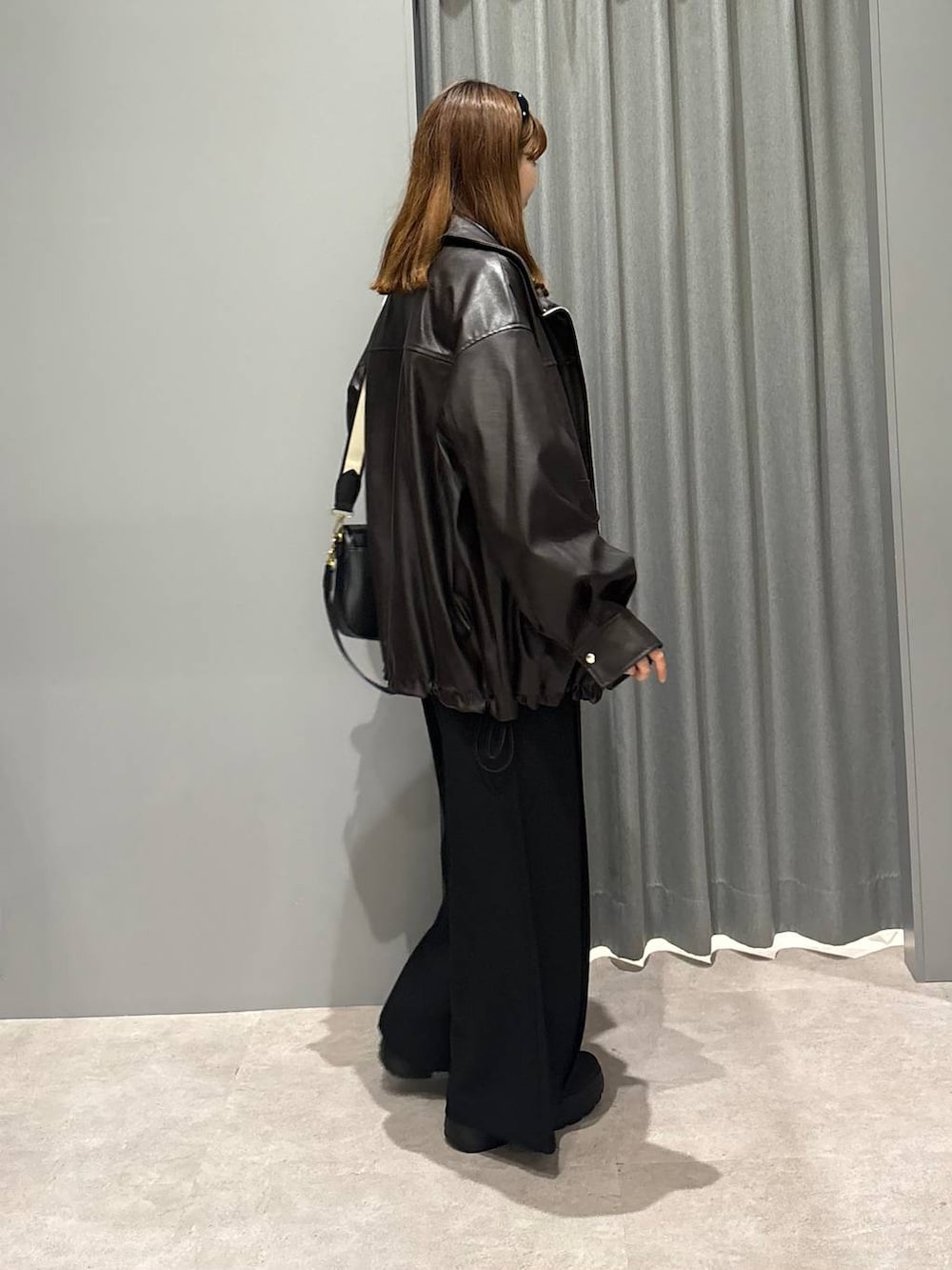 ブラック系のショルダーバッグ、ブルー系のシャツ/ブラウス、ブラウン系のブルゾンを着用したレディースの秋コーディネートの5枚目の写真