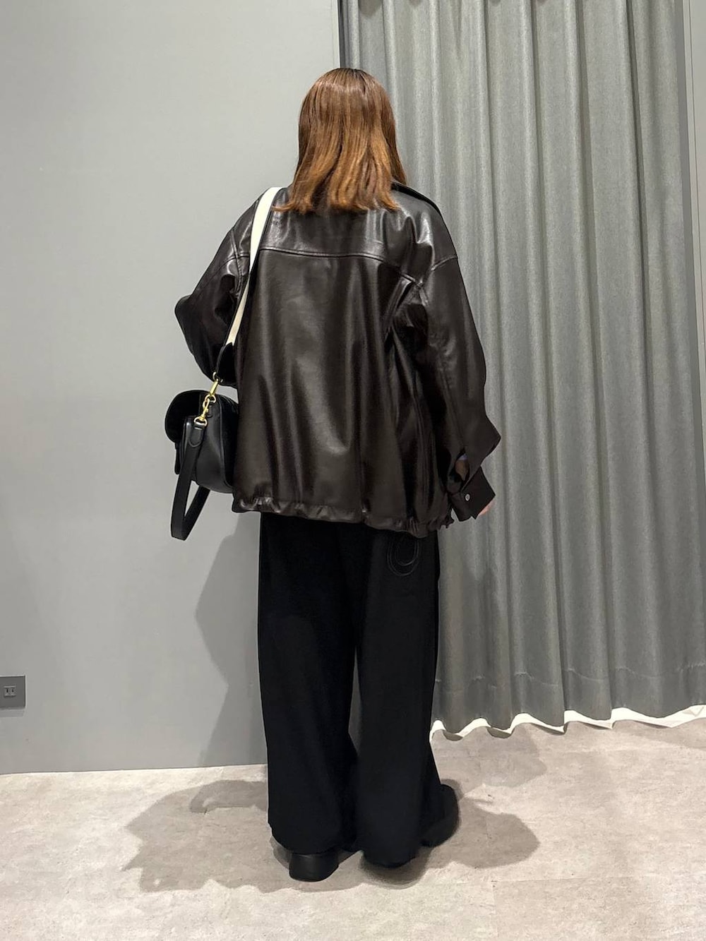 ブラック系のショルダーバッグ、ブルー系のシャツ/ブラウス、ブラウン系のブルゾンを着用したレディースの秋コーディネートの4枚目の写真