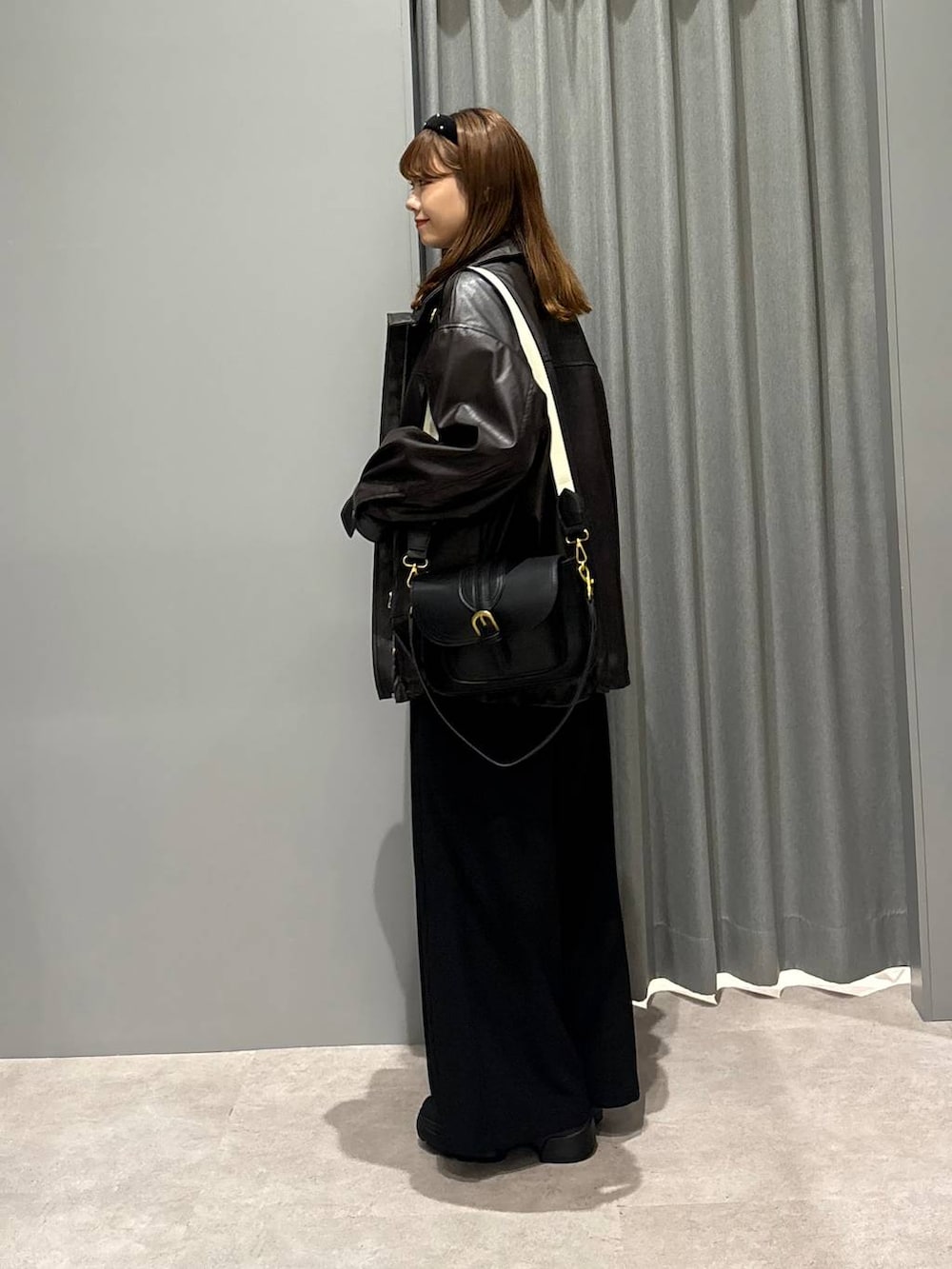 ブラック系のショルダーバッグ、ブルー系のシャツ/ブラウス、ブラウン系のブルゾンを着用したレディースの秋コーディネートの3枚目の写真