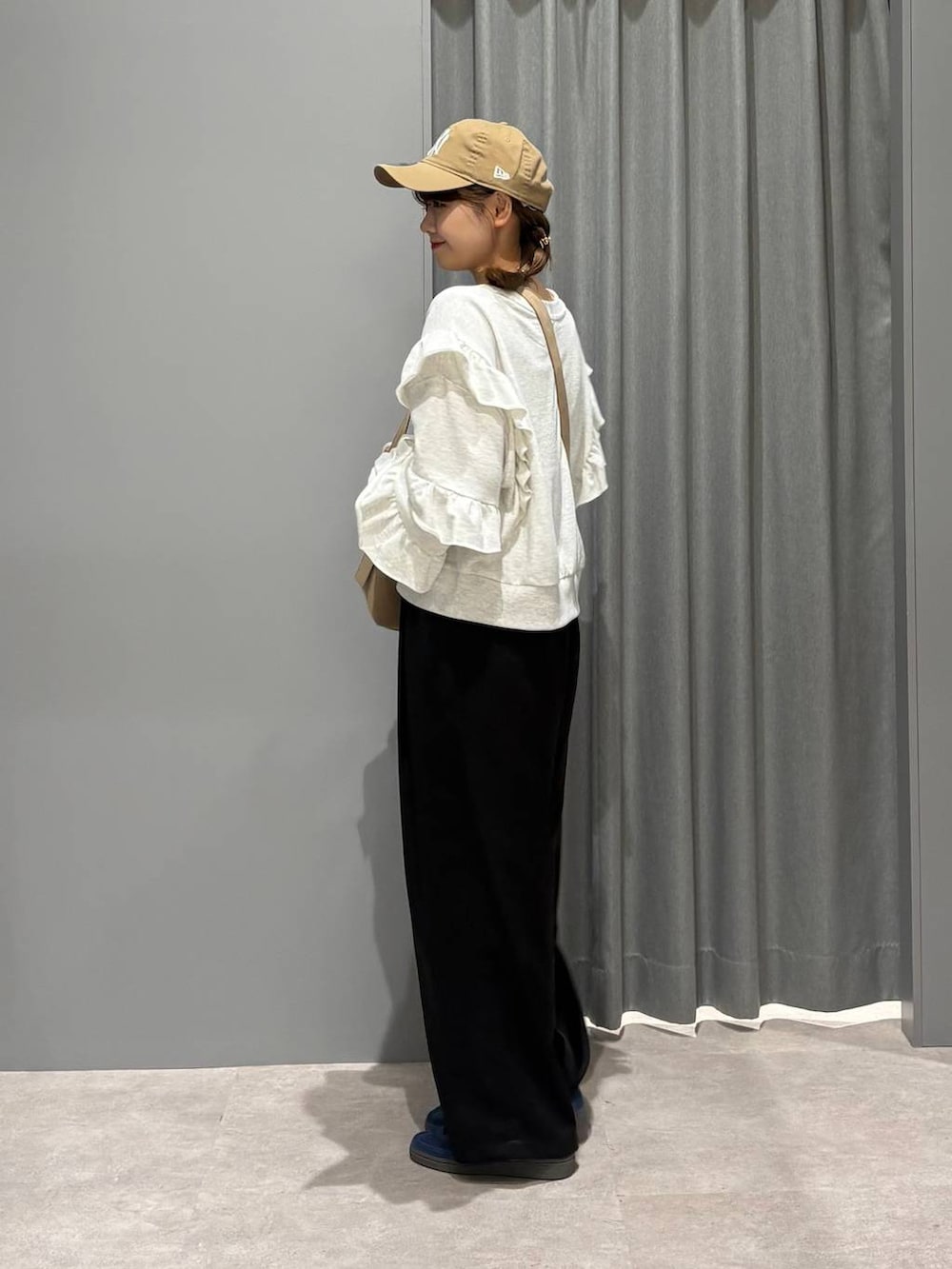 ブルー系のスニーカー、ベージュ系のショルダーバッグ、ブラック系のその他パンツを着用したレディースの秋コーディネートの2枚目の写真