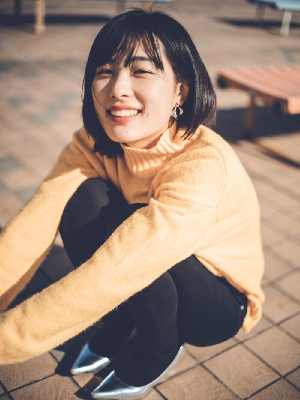 ブラック系のパンツ、イエロー系のニット/セーター、シルバー系のパンプスを着用したレディースの秋コーディネートの2枚目の写真