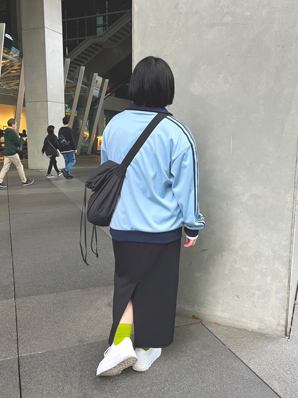 ブルー系のジャージ、ホワイト系のスニーカーを着用したレディースの春コーディネートの2枚目の写真