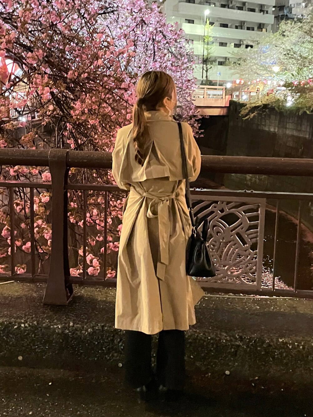 ベージュ系のトレンチコート、ホワイト系のシャツ/ブラウス、ブラック系のパンツを着用したレディースの春コーディネートの2枚目の写真