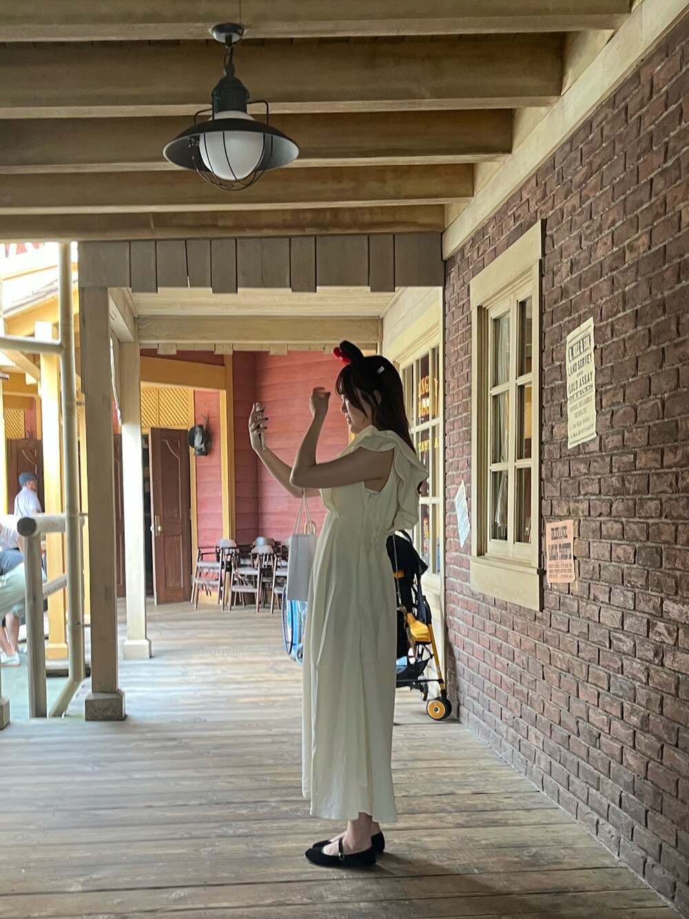 ホワイト系のワンピース、ブラック系のバッグを着用したレディースの秋コーディネートの3枚目の写真