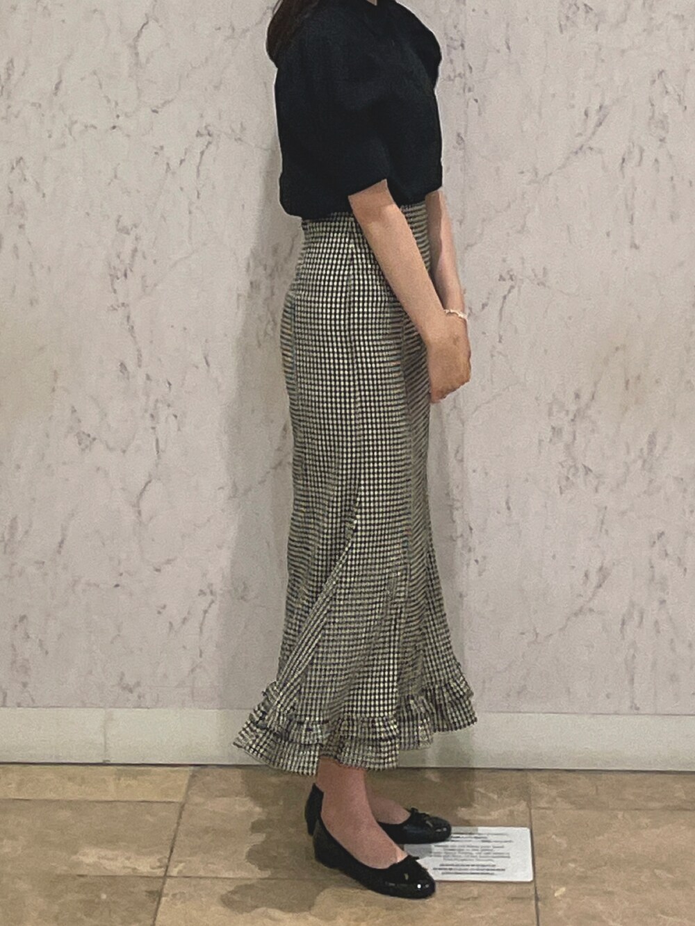 ブラック系のパンプス、ブラック系のスカート、ブラック系のシャツ/ブラウスを着用したレディースの秋コーディネートの2枚目の写真