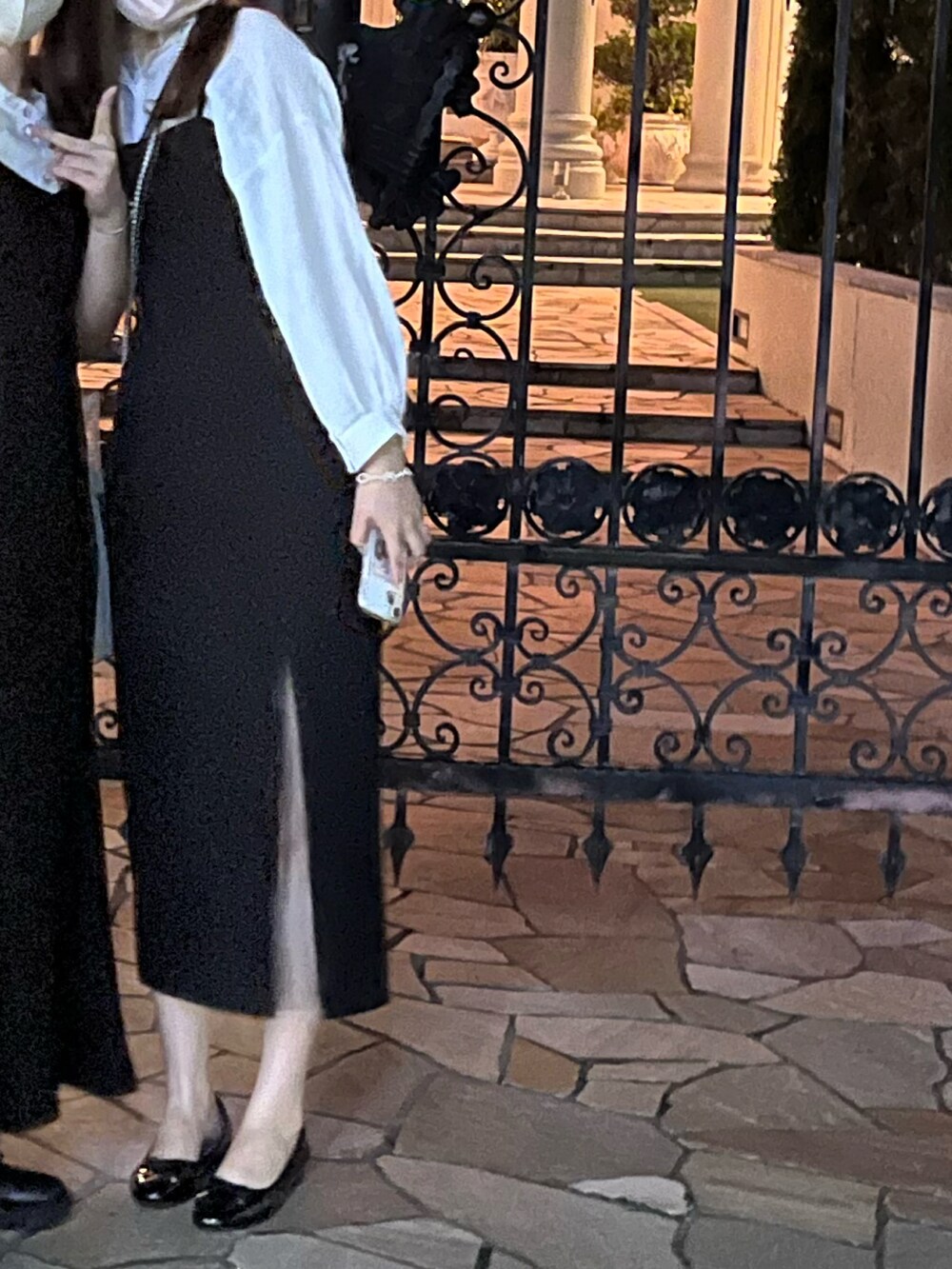 ブラック系のショルダーバッグ、ホワイト系のトップス、ブラック系のバレエシューズを着用したレディースの春コーディネートの2枚目の写真