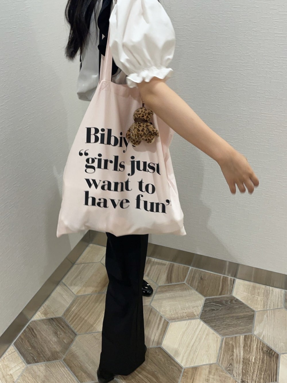 ブラック系のパンプス、ピンク系のトートバッグ、ホワイト系のシャツ/ブラウスを着用したレディースの冬コーディネートの2枚目の写真