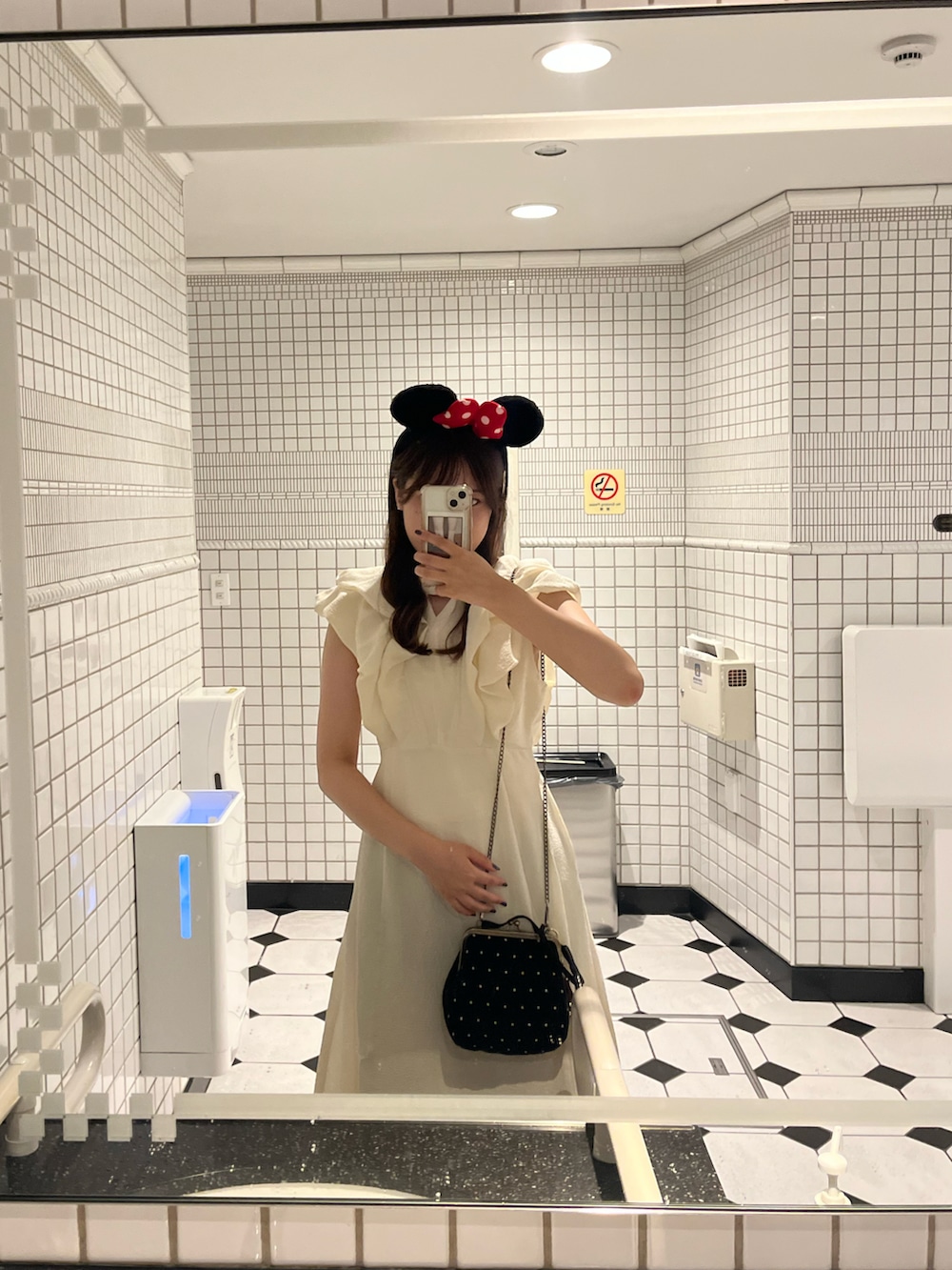 ホワイト系のワンピース、ブラック系のバッグを着用したレディースの秋コーディネートの2枚目の写真