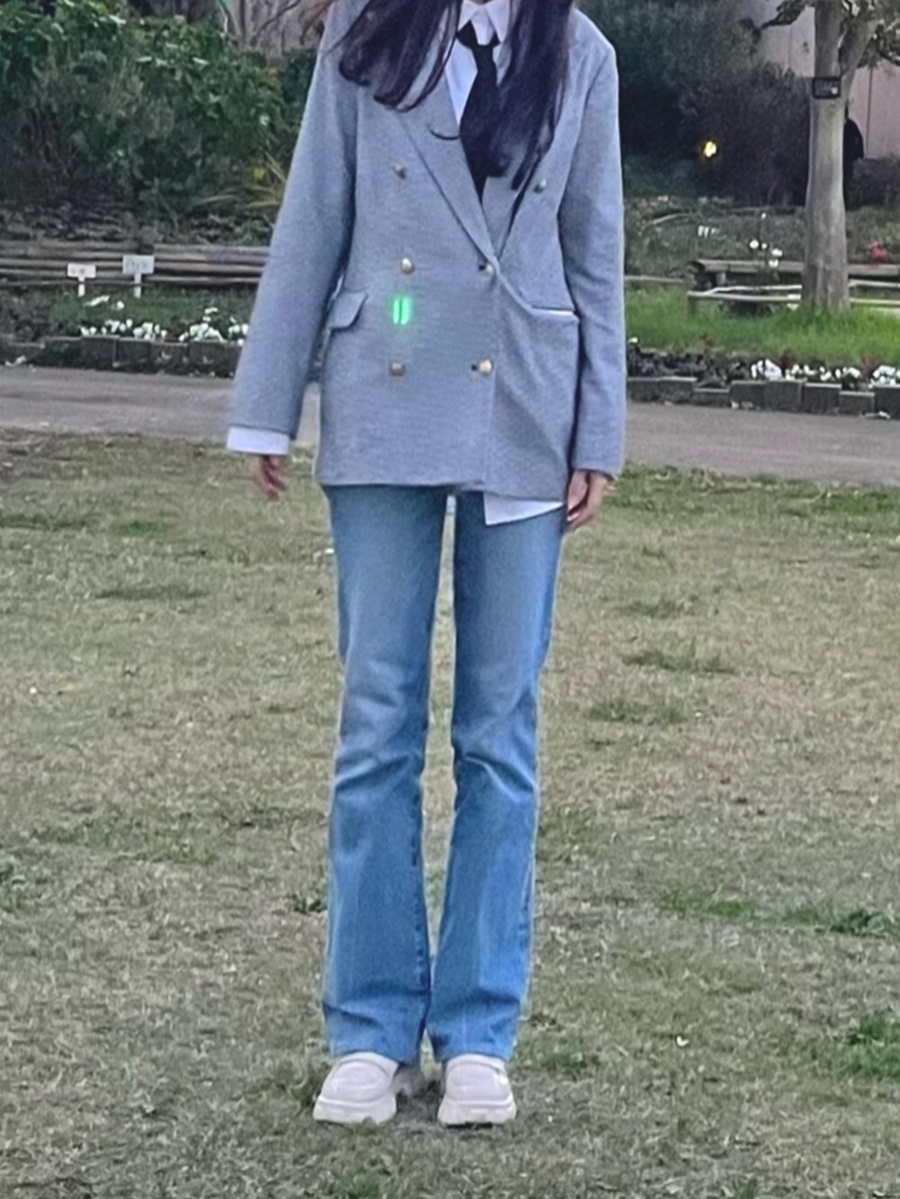 ブルー系のデニムパンツ、ホワイト系のローファー、ブラック系のテーラードジャケットを着用したレディースの秋コーディネートの2枚目の写真