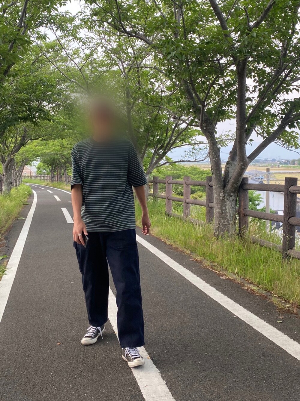 グリーン系のTシャツ/カットソー、ブルー系のデニムパンツ、ブラック系のスニーカーを着用したメンズの夏コーディネートの2枚目の写真