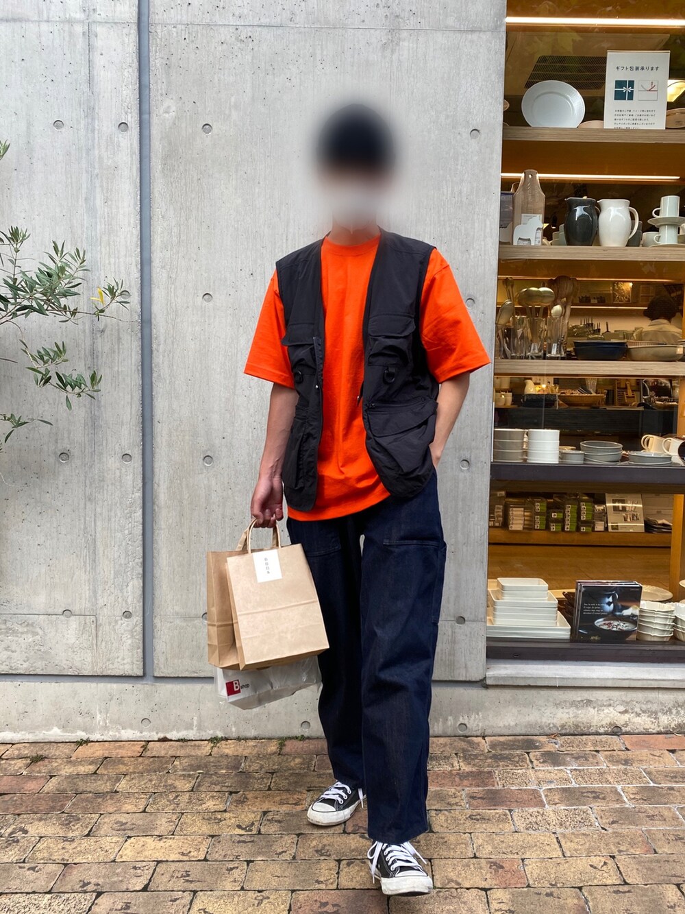 オレンジ系のTシャツ/カットソー、ブルー系のデニムパンツ、ブラック系のスニーカーを着用したメンズの夏コーディネートの2枚目の写真