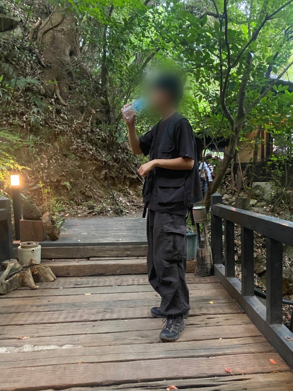 ブラック系のTシャツ/カットソー、ブラック系のベスト、ブラック系のカーゴパンツを着用したメンズの夏コーディネートの2枚目の写真