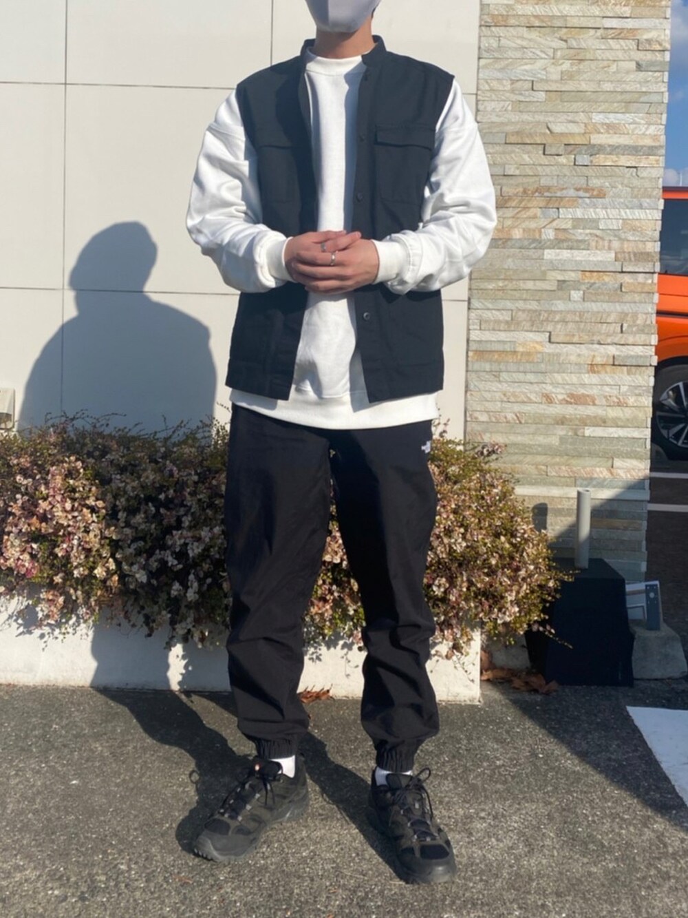 ブラック系のジャケット/アウター、ホワイト系のスウェット、ブラック系のベストを着用したメンズの冬コーディネートの2枚目の写真
