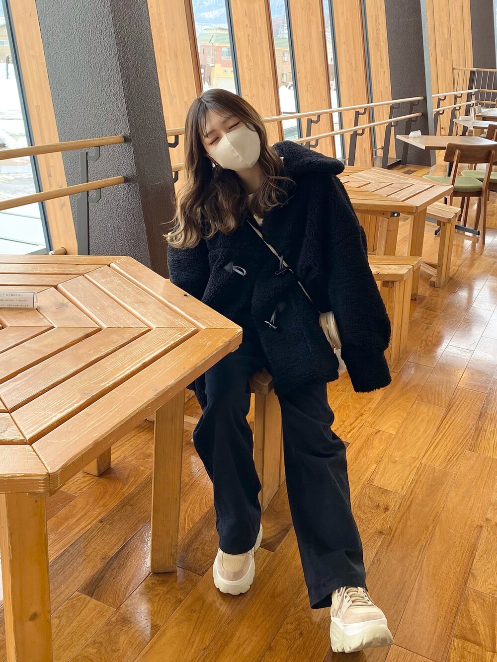 ベージュ系のスニーカー、ブラック系のダッフルコート、ホワイト系のスウェットを着用したレディースの冬コーディネートの2枚目の写真