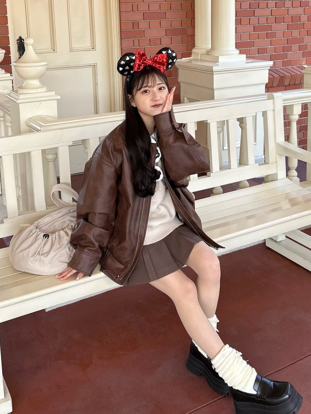 ホワイト系のニット/セーター、ブラウン系のスカート、ブラウン系のブルゾンを着用したレディースの冬コーディネートの4枚目の写真