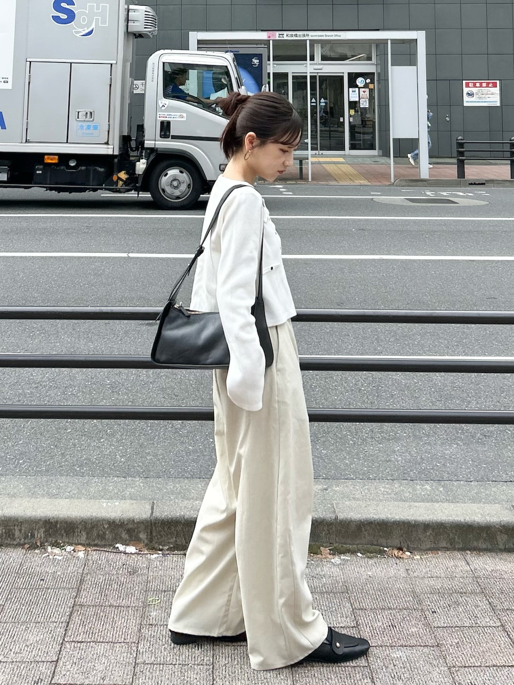 ホワイト系のスラックス、ホワイト系のカーディガン/ボレロ、ブラック系のトートバッグを着用したレディースの秋コーディネートの3枚目の写真