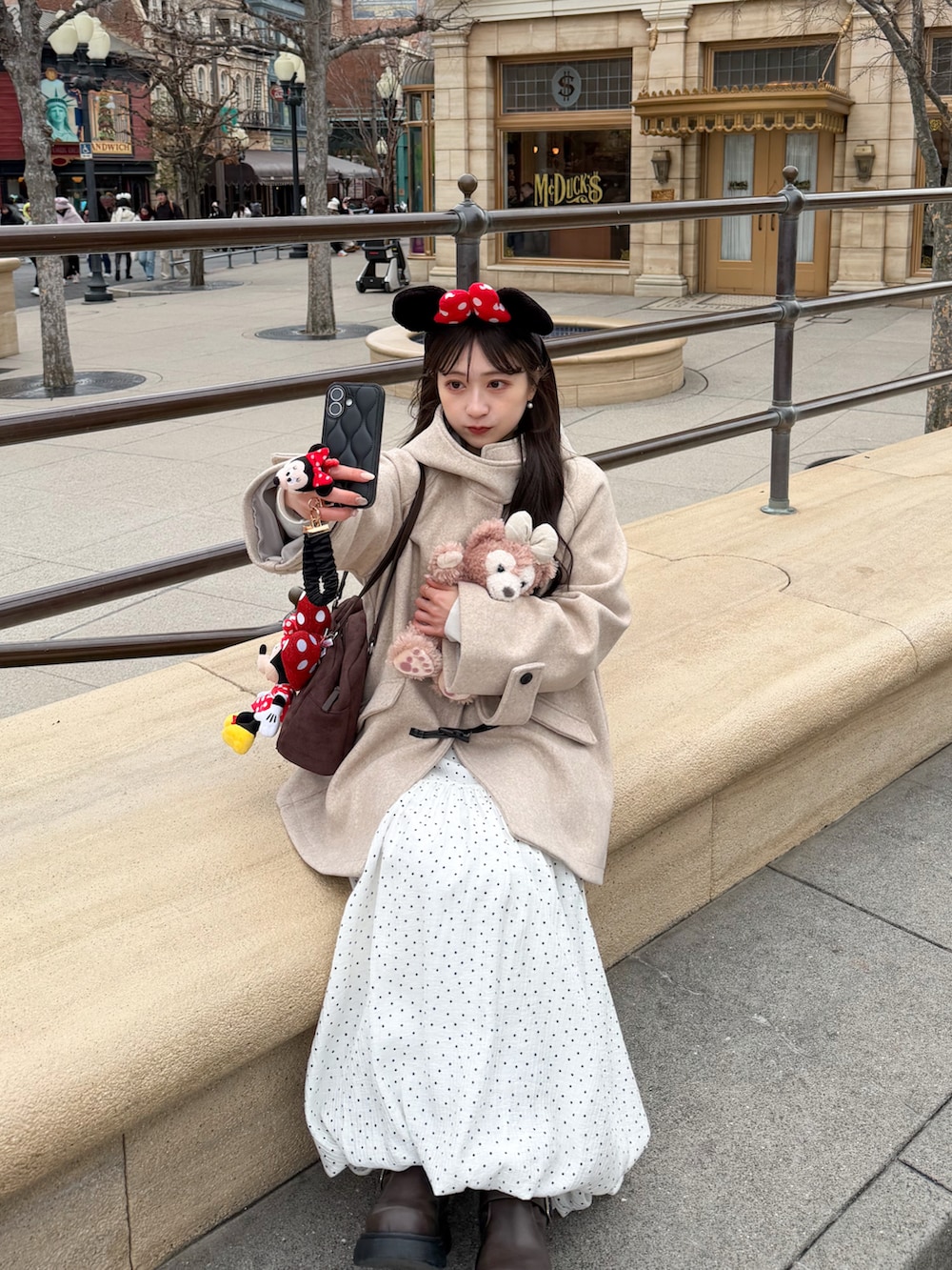 ホワイト系のスカート、ベージュ系のその他アウター、ブラウン系のボストンバッグを着用したレディースの冬コーディネートの4枚目の写真