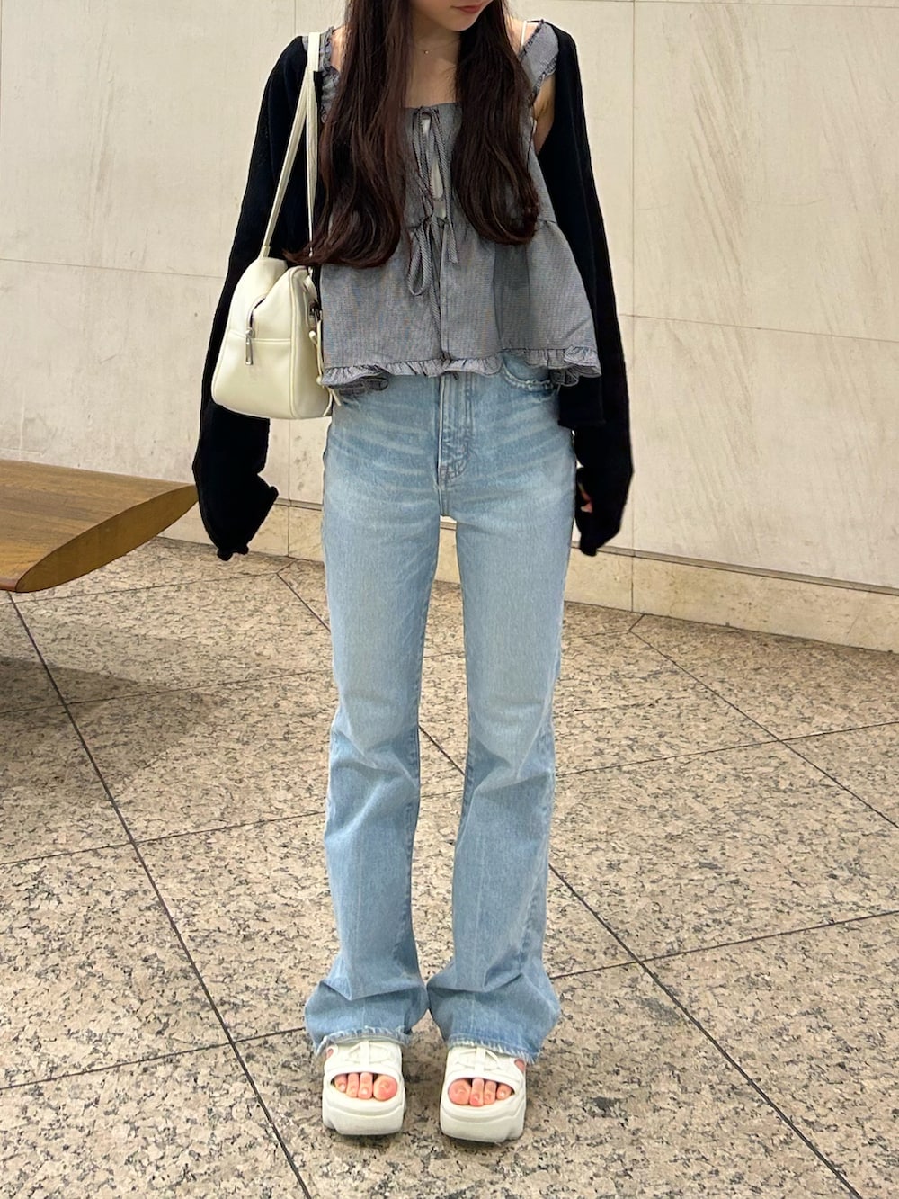 ブルー系のデニムパンツ、ホワイト系のショルダーバッグ、ベージュ系のサンダルを着用したレディースの夏コーディネートの4枚目の写真