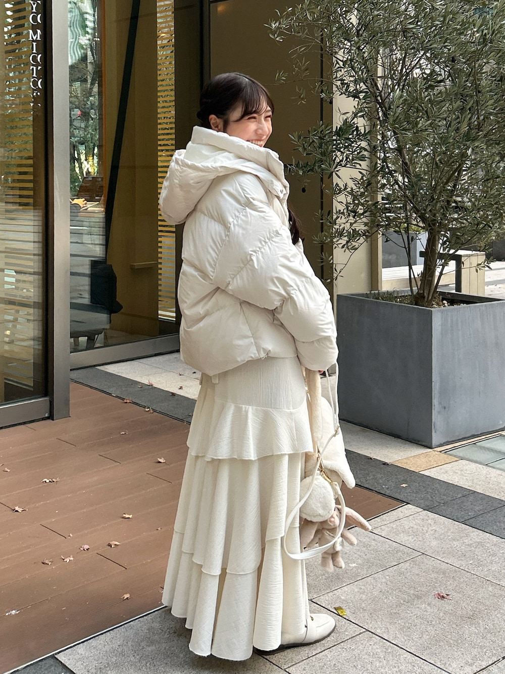 ホワイト系のショルダーバッグ、ピンク系のワンピース、ブラウン系のカーディガン/ボレロを着用したレディースの冬コーディネートの3枚目の写真