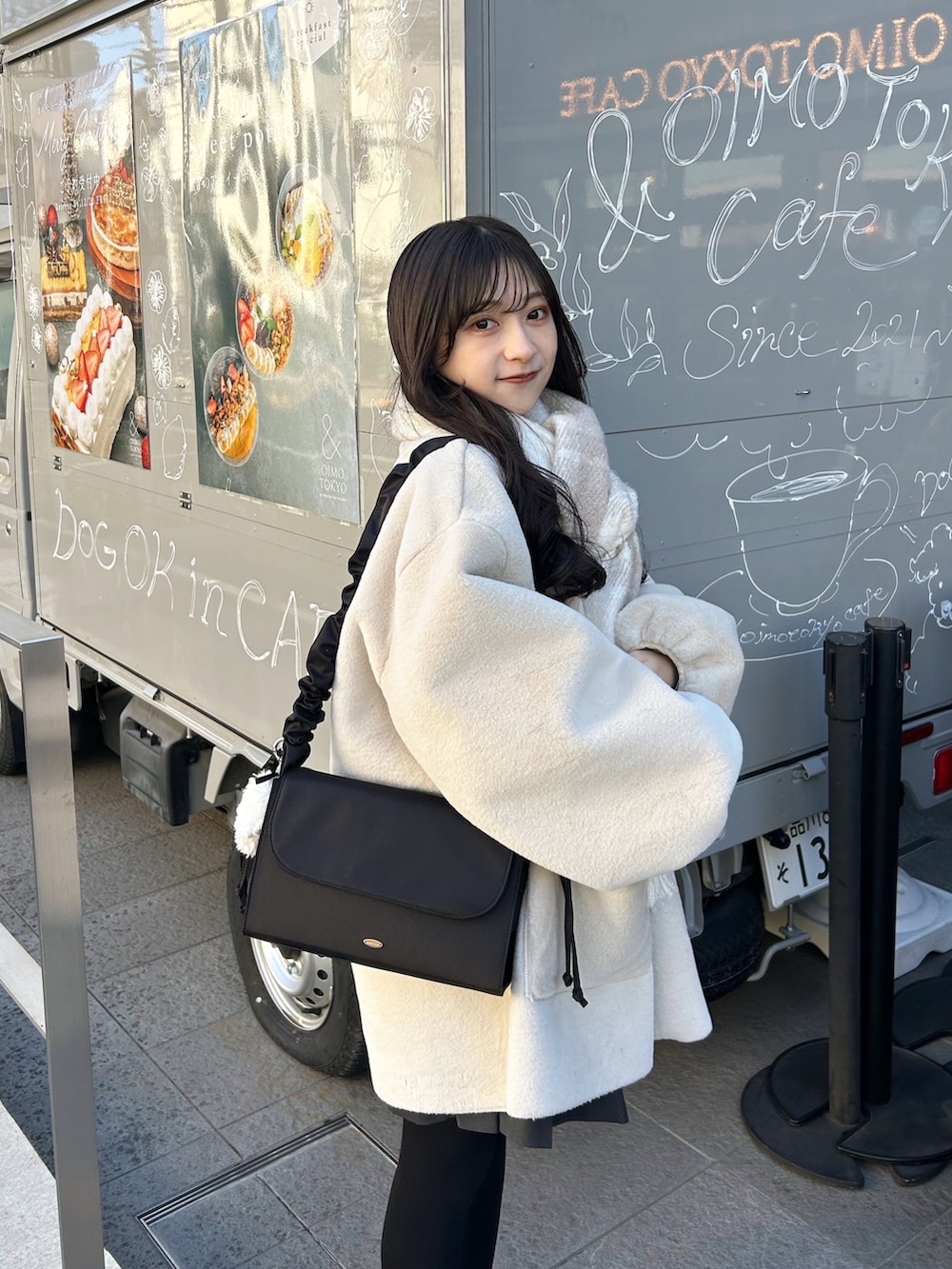 ブラック系のバッグ、ベージュ系のブーツ、ホワイト系のその他アウターを着用したレディースの冬コーディネートの5枚目の写真