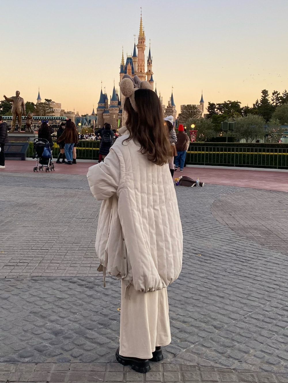 ベージュ系のショルダーバッグ、ホワイト系のダウンジャケット/コート、ホワイト系のニット/セーターを着用したレディースの冬コーディネートの5枚目の写真