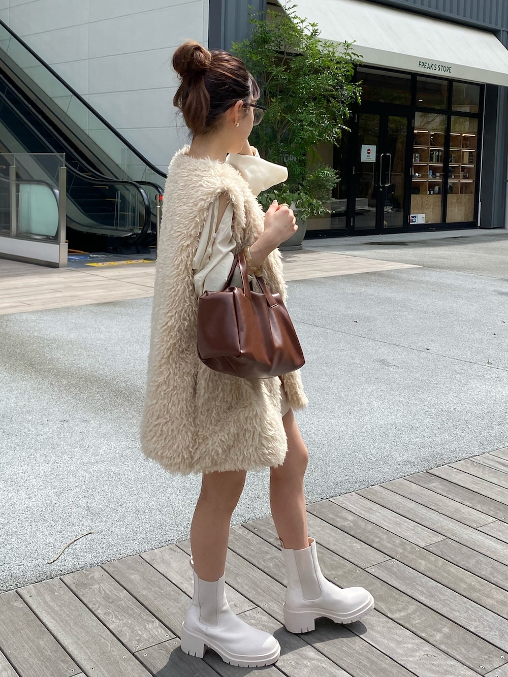 ブラウン系のボストンバッグ、ホワイト系のその他パンツ、ホワイト系のシャツ/ブラウスを着用したレディースの秋コーディネートの2枚目の写真