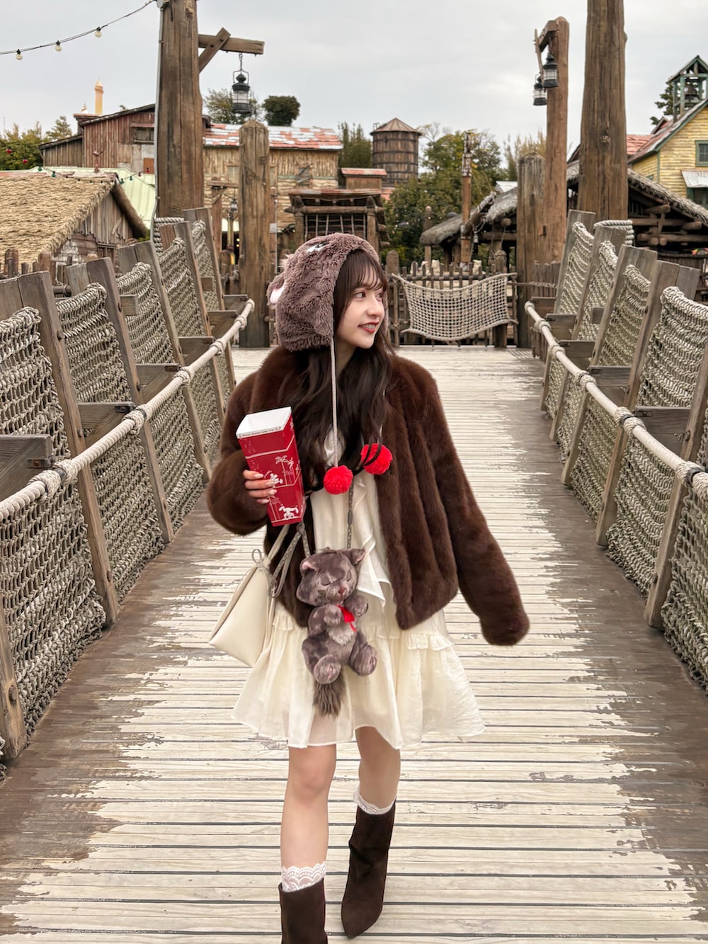 ブラウン系のブーツ、ホワイト系のワンピース、ブラウン系のジャケット/アウターを着用したレディースの春コーディネートの4枚目の写真