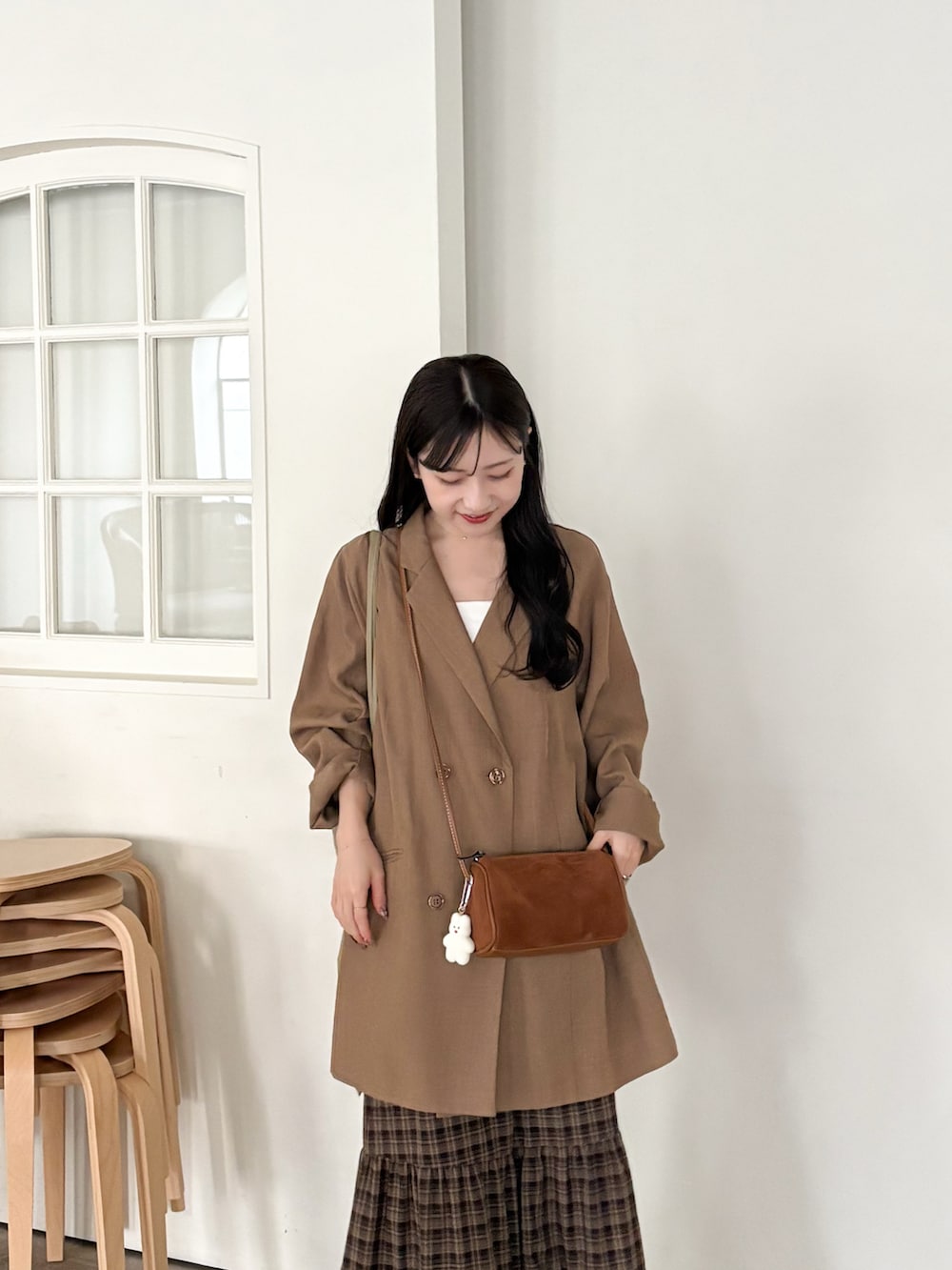 イエロー系のショルダーバッグ、ブラウン系のテーラードジャケット、ブラウン系のブーツを着用したレディースの秋コーディネートの5枚目の写真