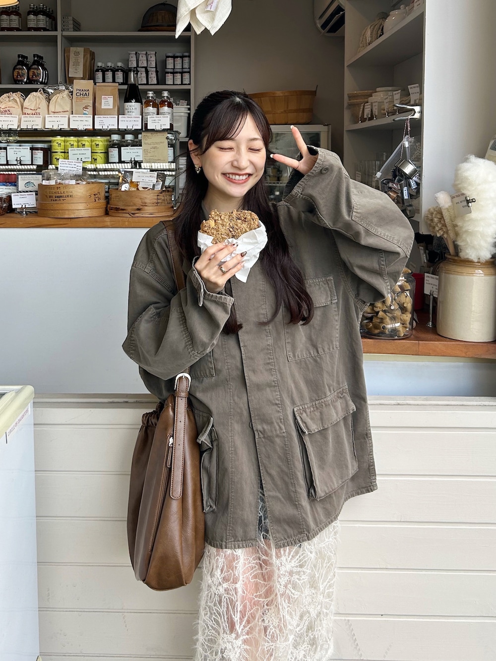 ブラウン系のデニムジャケット、ブラウン系のショルダーバッグ、ブラウン系のブーツを着用したレディースの秋コーディネートの3枚目の写真