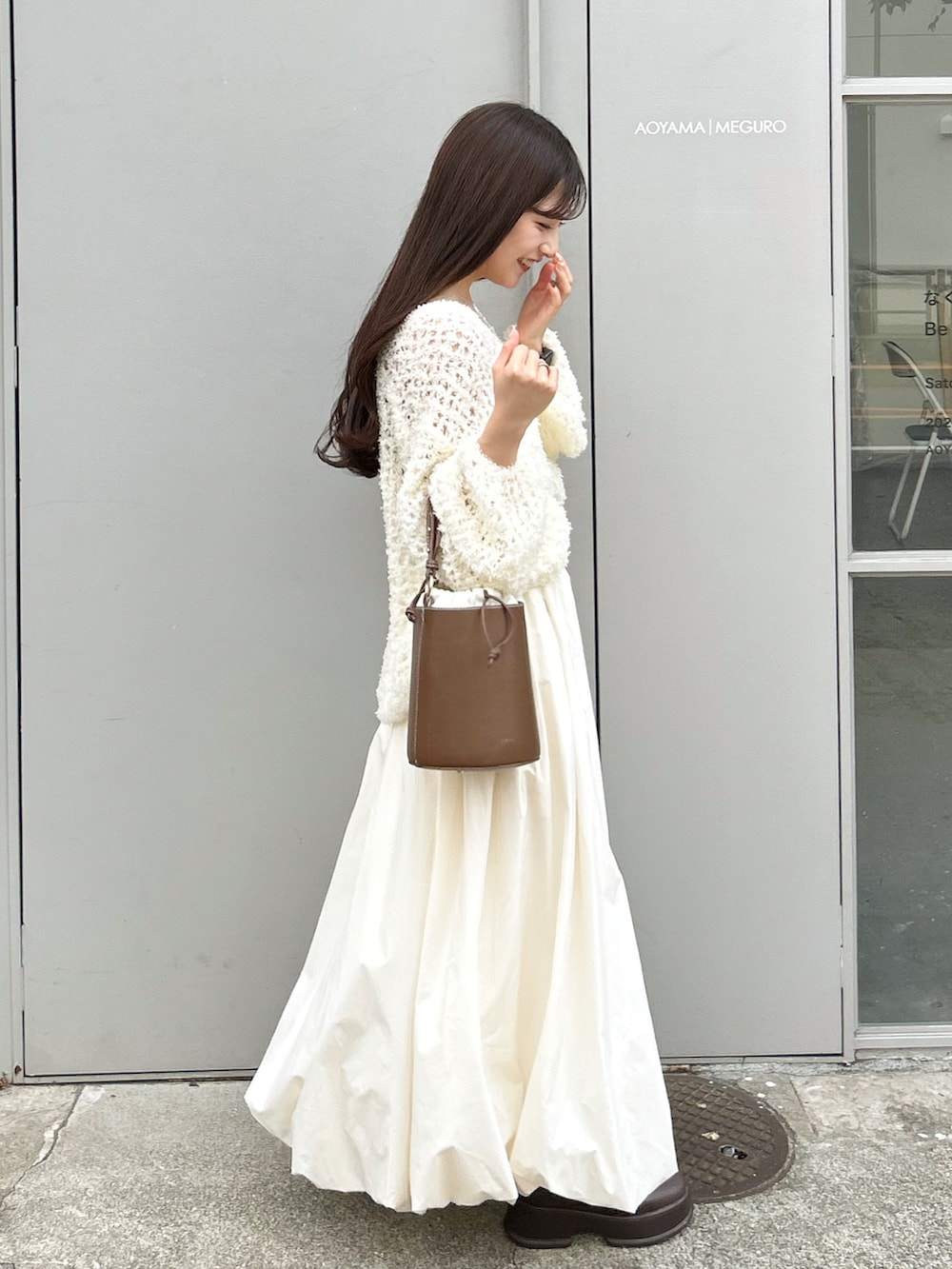 ブラウン系のハンドバッグ、ホワイト系のワンピース、ホワイト系のスカートを着用したレディースの秋コーディネートの3枚目の写真