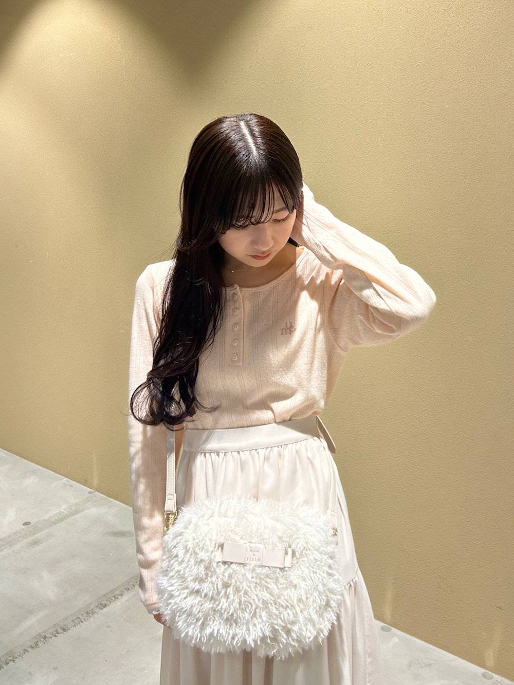 ブラウン系のブルゾン、ピンク系のTシャツ/カットソー、ホワイト系のスカートを着用したレディースの冬コーディネートの3枚目の写真