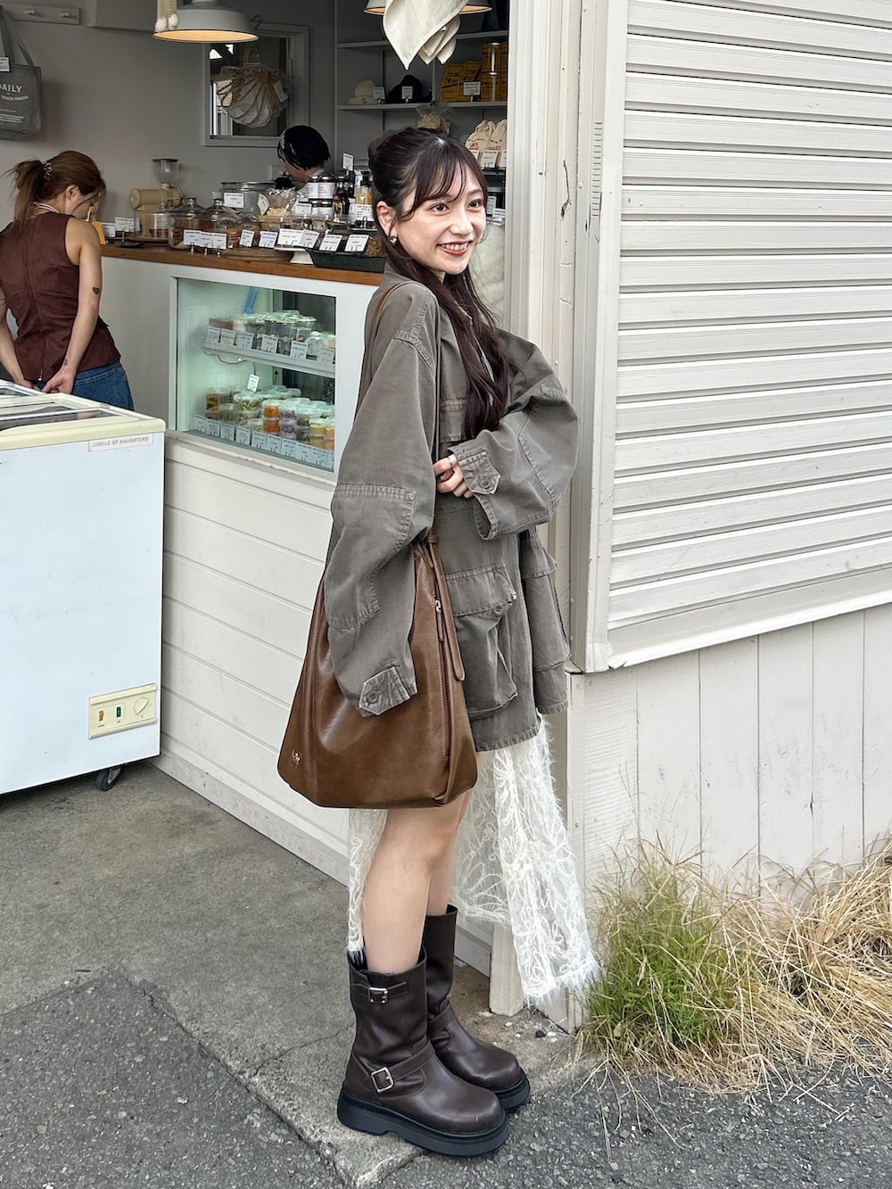 ブラウン系のデニムジャケット、ブラウン系のショルダーバッグ、ブラウン系のブーツを着用したレディースの秋コーディネートの2枚目の写真