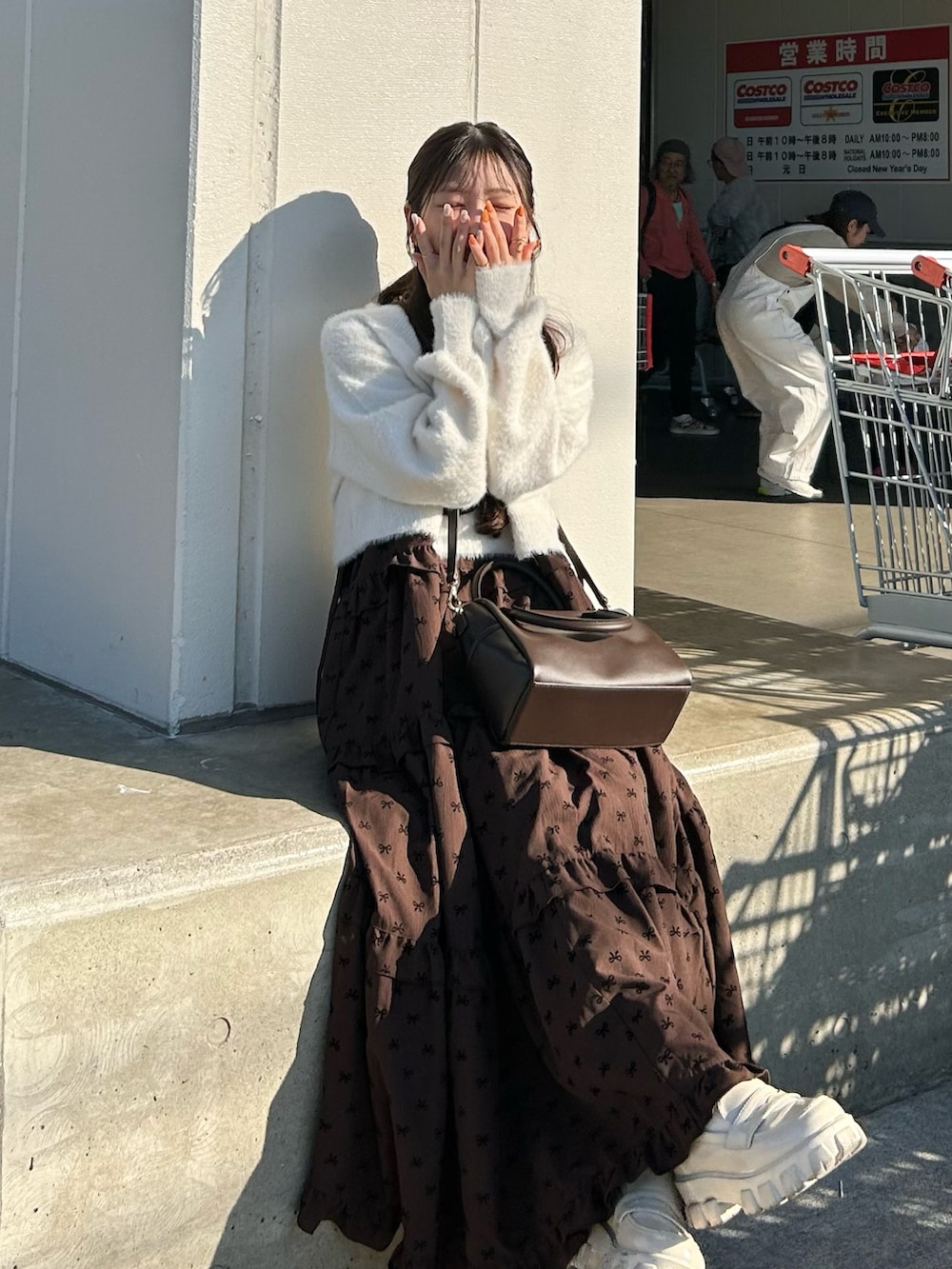 ブラウン系のバッグ、ホワイト系のローファー、ホワイト系のセットアップを着用したレディースの秋コーディネートの3枚目の写真