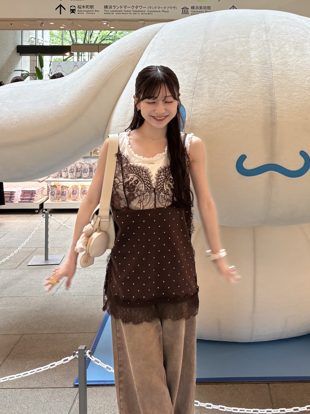 ホワイト系のタンクトップ、ブラウン系のデニムパンツ、ブラウン系のキャミソールを着用したレディースの夏コーディネートの3枚目の写真