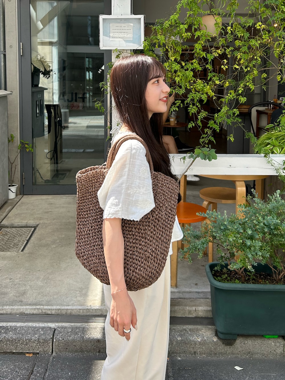 ホワイト系のその他パンツ、ブラウン系のトートバッグ、ホワイト系のシャツ/ブラウスを着用したレディースの夏コーディネートの2枚目の写真