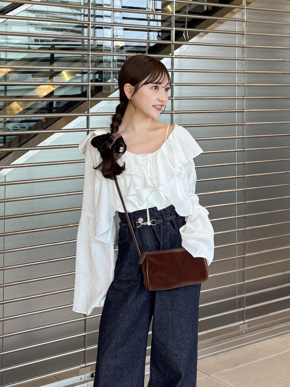 ブルー系のデニムパンツ、ブラウン系のローファー、ホワイト系のシャツ/ブラウスを着用したレディースの秋コーディネートの3枚目の写真