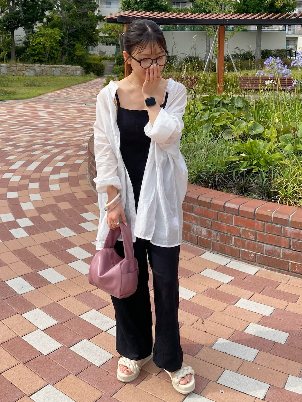 ピンク系のボストンバッグ、ホワイト系のシャツ/ブラウス、ホワイト系のサンダルを着用したレディースの夏コーディネートの2枚目の写真