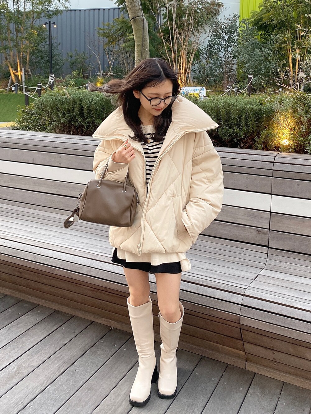 ベージュ系のショルダーバッグ、ホワイト系のTシャツ/カットソー、ホワイト系のダウンジャケット/コートを着用したレディースの冬コーディネートの2枚目の写真